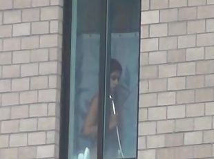 Voyeur peeps through the window of the girl's lockerroom